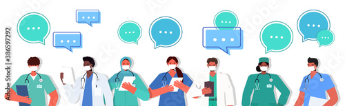 mix race doctors in uniform wearing masks to prevent coronavirus pandemic chat bubble communication concept medical workers team standing together portrait horizontal vector illustration