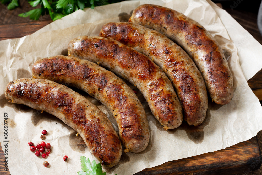 Fried sausages. Grilled sausages with spices on a wooden serving Board. Delicious meat sausages Fried sausages. Grilled sausages with spices on a wooden serving Board. Delicious meat sausages