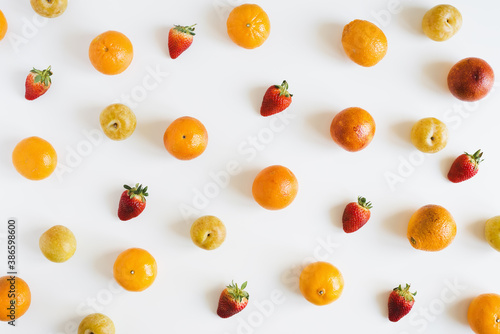 Fruit and berry pattern on white background. Oranges, yellow plum and strawberry