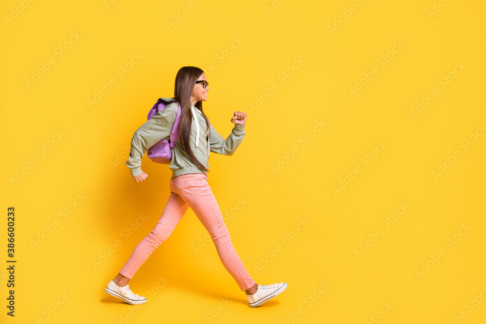 Full length portrait of student walking hurry wear stylish hoodie isolated on vivid yellow color background