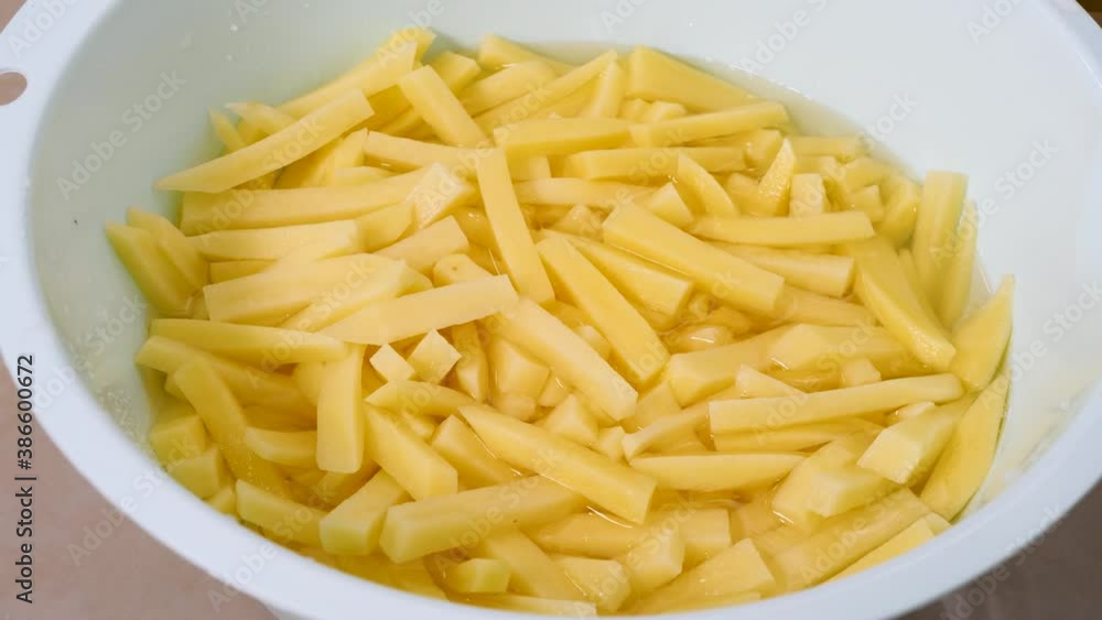 Raw and sliced potatoes at kitchen. Cooking potato dishes. Sliced vegetables in white bowl. Health vegan organic food Raw and sliced potatoes at kitchen. Cooking potato dishes. Sliced vegetables in white bowl. Health vegan organic food
