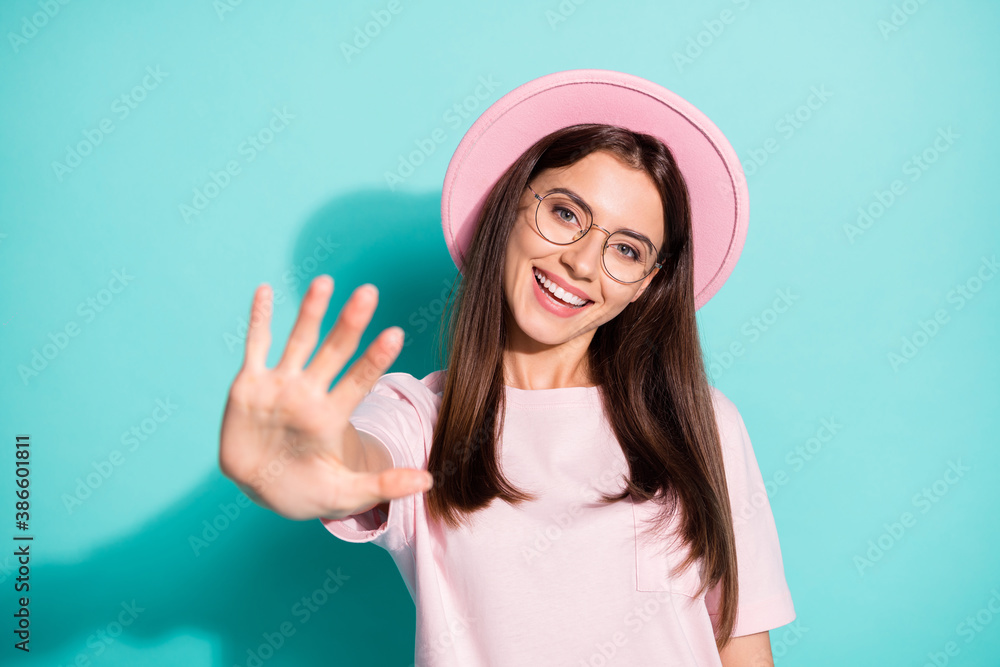 Photo of excited charming girl wave hand in camera wear spring time clothes isolated over turquoise color background Photo of excited charming girl wave hand in camera wear spring time clothes isolated over turquoise color background