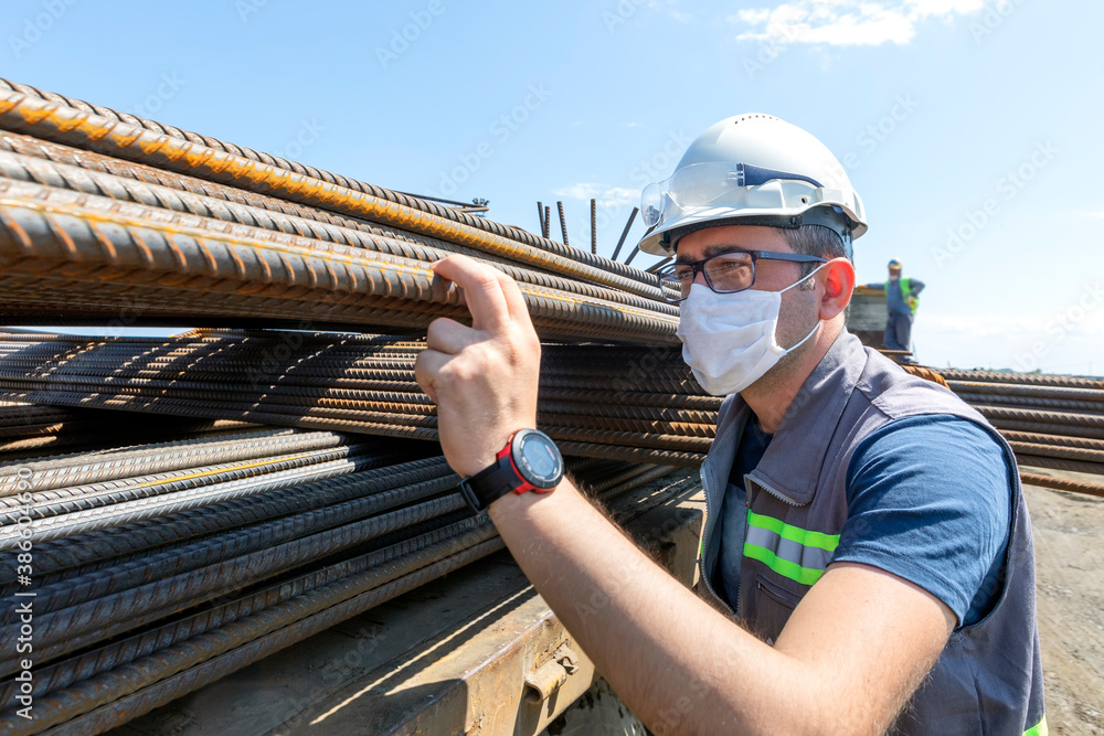 The inspector is checking to rebars in the construction site. Rebar (short for reinforcing bar