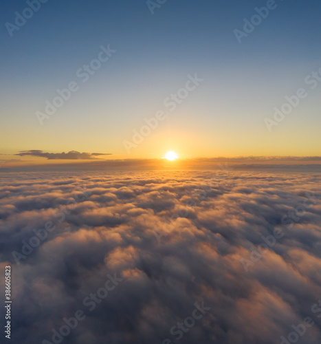 Beautiful sunrais cloudy sky from aerial view. Airplane view above clouds