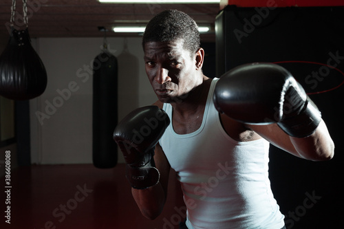 Confident afro american boxer holds training in the ring. High quality pot © JackF