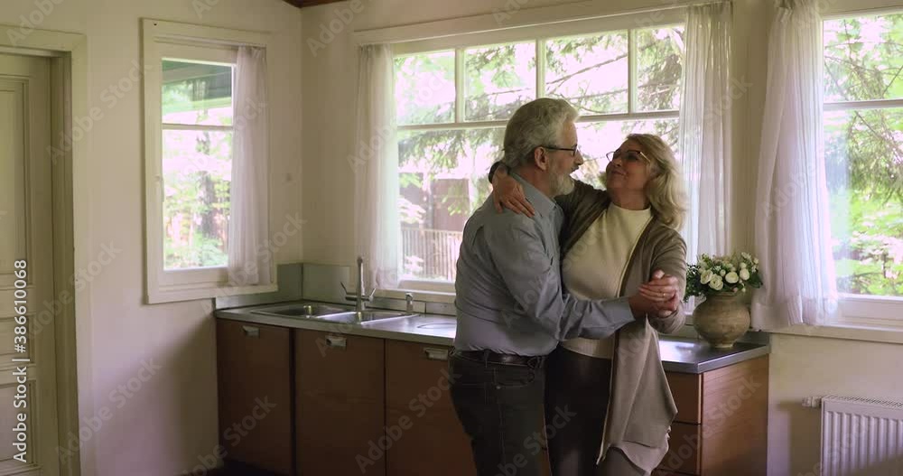 Active couple dancing in home kitchen, holding hands swirling feeling love. Having fun, pastime and hobby, happy vivacious retirees enjoy new day and date, romantic relations of mature people concept Active couple dancing in home kitchen, holding hands swirling feeling love. Having fun, pastime and hobby, happy vivacious retirees enjoy new day and date, romantic relations of mature people concept