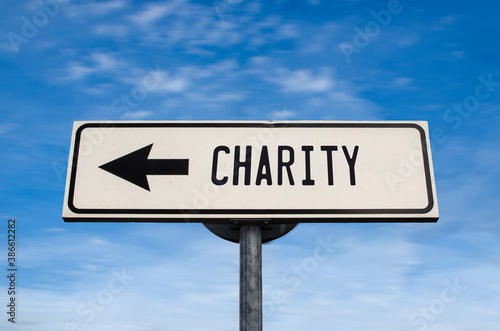 Charity road sign, arrow on blue sky background. One way blank road sign with copy space. Arrow on a pole pointing in one direction.