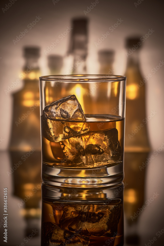 A glass of whiskey with ice. A glass of whiskey with ice.