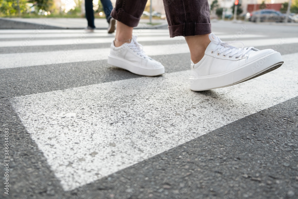female feet crossing the crosswalk
female feet crossing the crosswalk