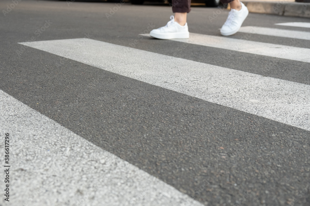 female feet crossing the crosswalk