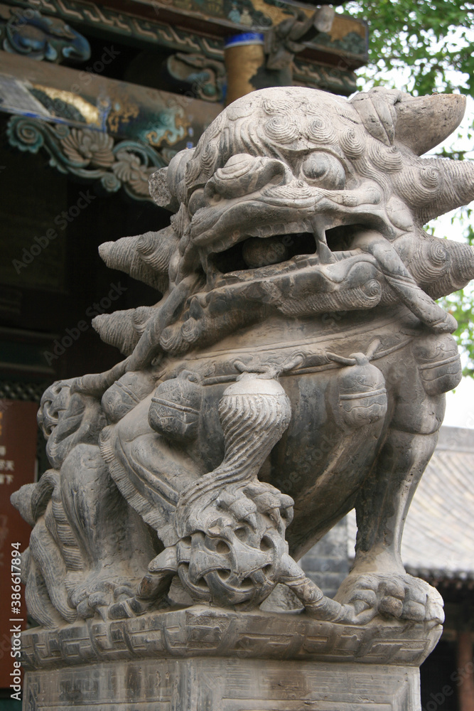 statue of a chinese guardian lion in a taoist temple (qing xu guan) in pingyao in china