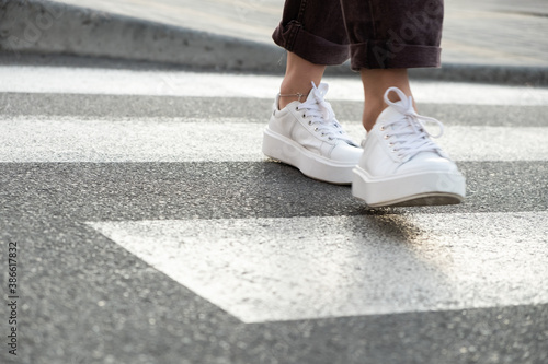 female feet crossing the crosswalk