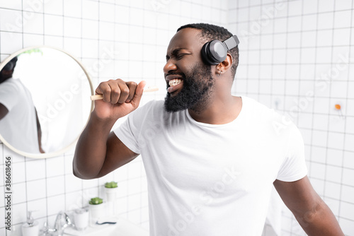 afro-american man with headphones singing in toothbrush