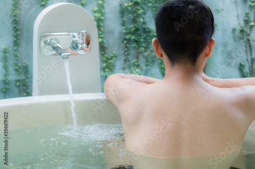 young asian man in  luxury bathtub spa relaxing in hotel