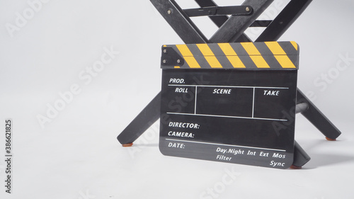 Director chair with black and yellow clapper board or movie slate on white background.it is used in video production and film industry.