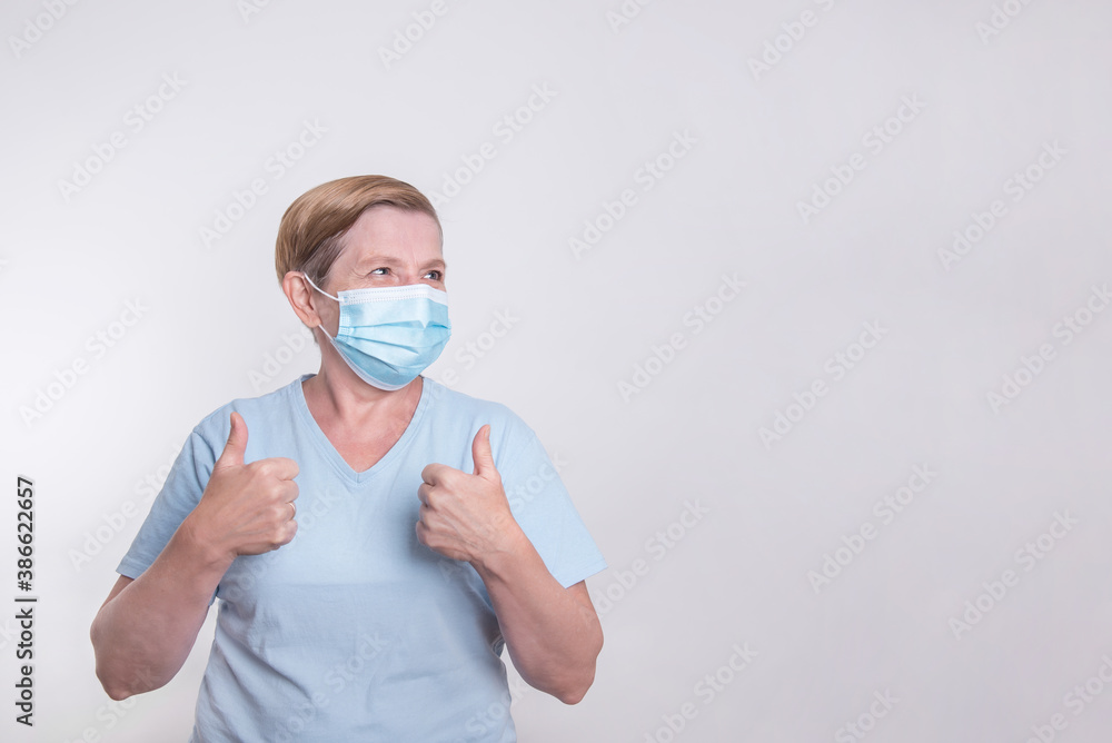 Elderly woman wearing mask and showing thumbs up Elderly woman wearing mask and showing thumbs up