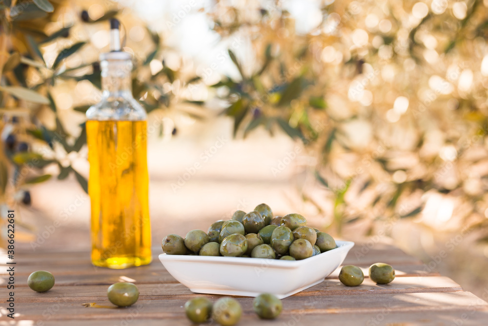 green olives and oil on table in olive grove green olives and oil on table in olive grove