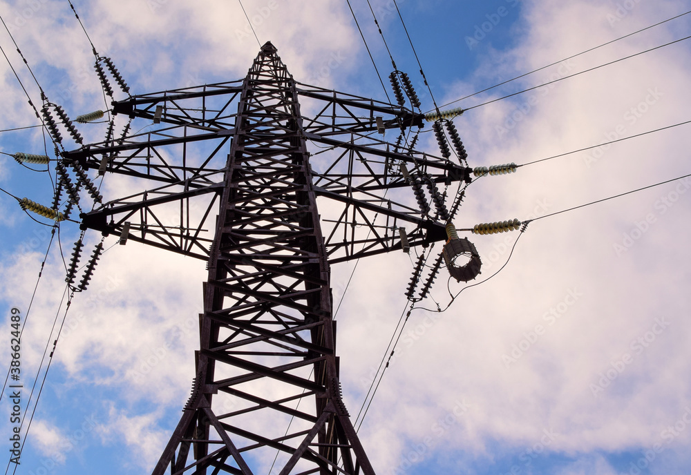 Power transmission tower against the sky. Bottom view. Electric power for transfer power by electrical grids. High voltage electric. Power transmission tower against the sky. Bottom view. Electric power for transfer power by electrical grids. High voltage electric.