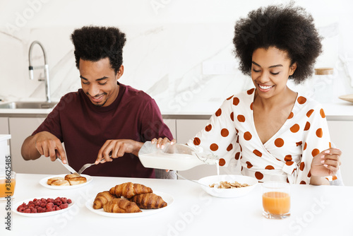 Happy young african couple having tasty breakfast