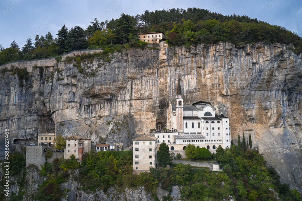 Italian church in the Alps. The unique Sanctuary Madonna della Corona church was built in the rock. Aerial view of the church on the sheer cliff. The sanctuary is high in the mountains of Italy.