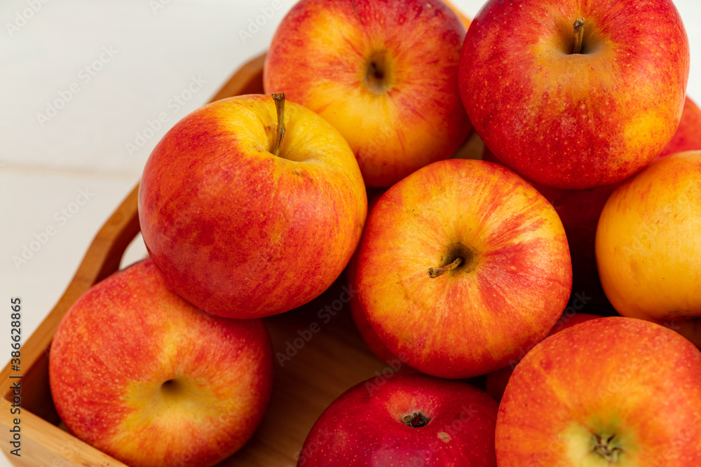 Pile of red apples on wooden tray Pile of red apples on wooden tray