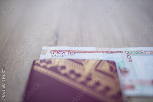 Ten Thousand Pesos Bill Partially inside a Swedish Passport