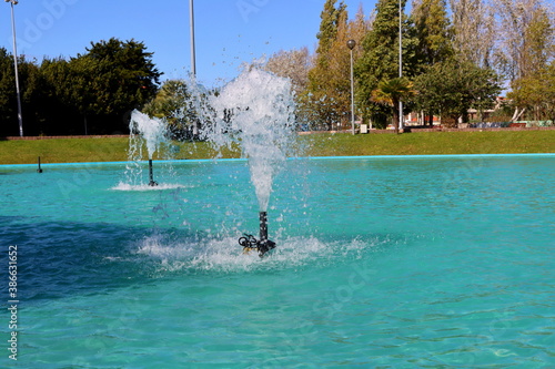 A fountain with splashes and drops of water works. Fountains in a pond with blue water.