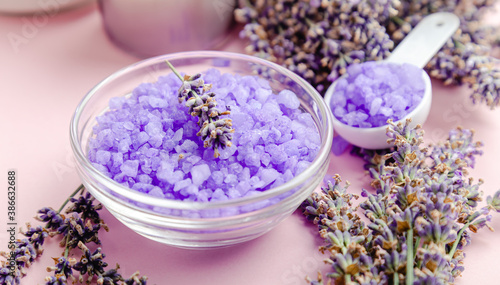 Lavender violet sea salt with lavender flowers. Lavender bath products Aromatherapy treatment on pink color background. Skincare spa beauty bath cosmetic products for relax.