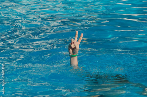 Hand coming out of the water, victory gesture