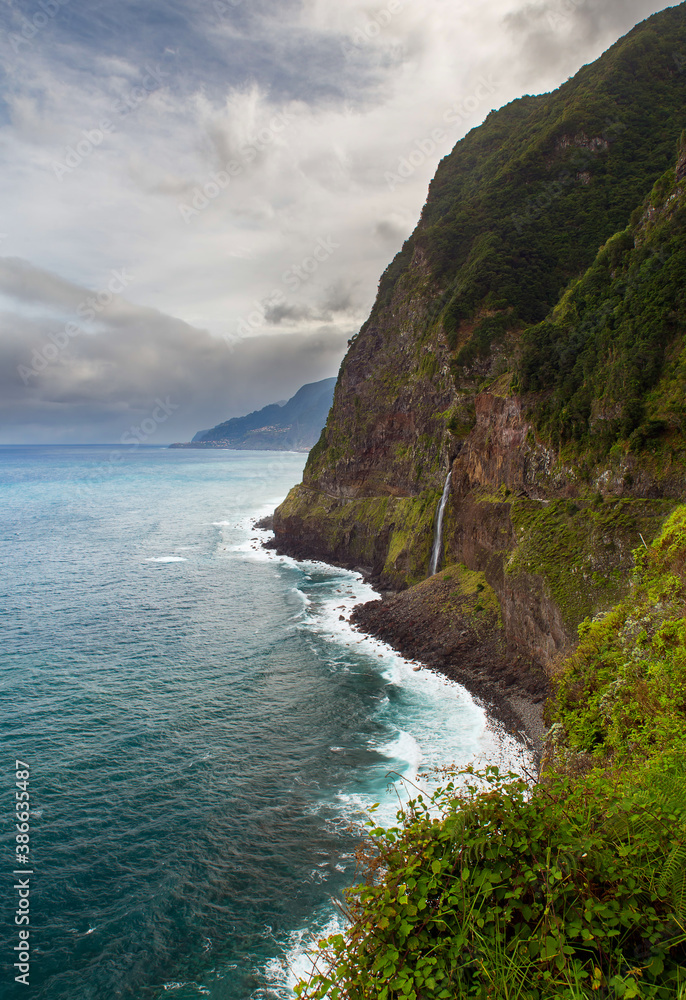 Coastal scenery from veu-de-noiva viewpoint in Seixal district for old coastal road with waterfall and steep cliffs in Madeira island, Portugal