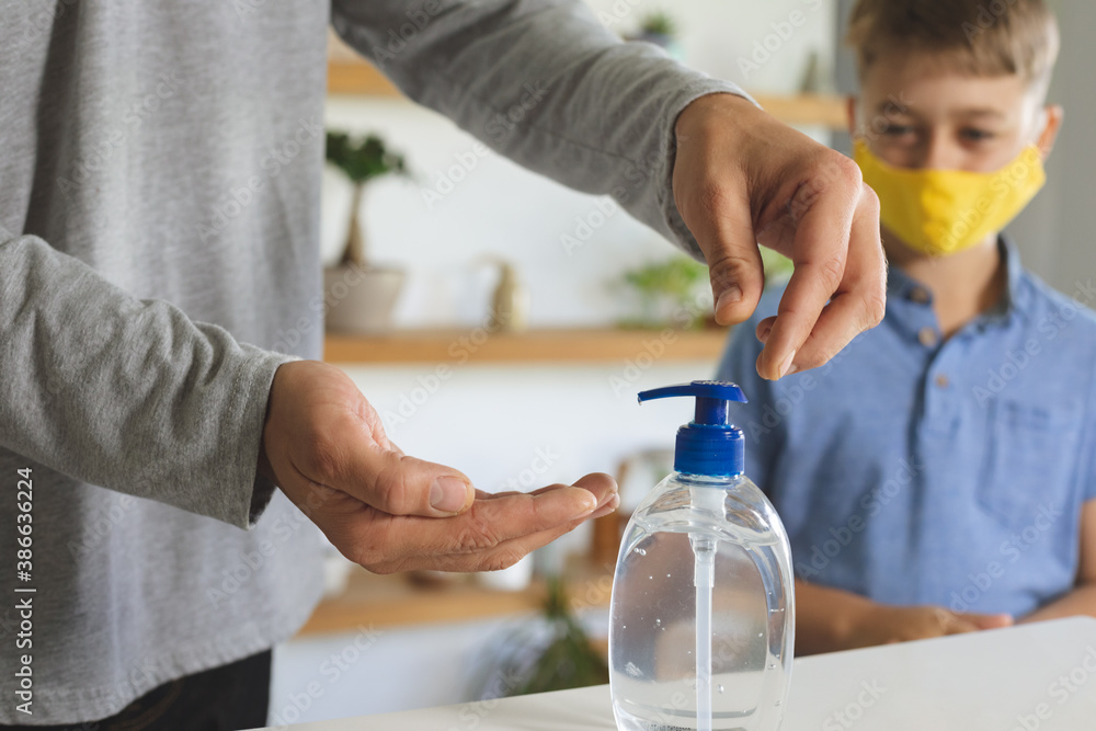 Mid section of man sanitizing his hands at home Mid section of man sanitizing his hands at home