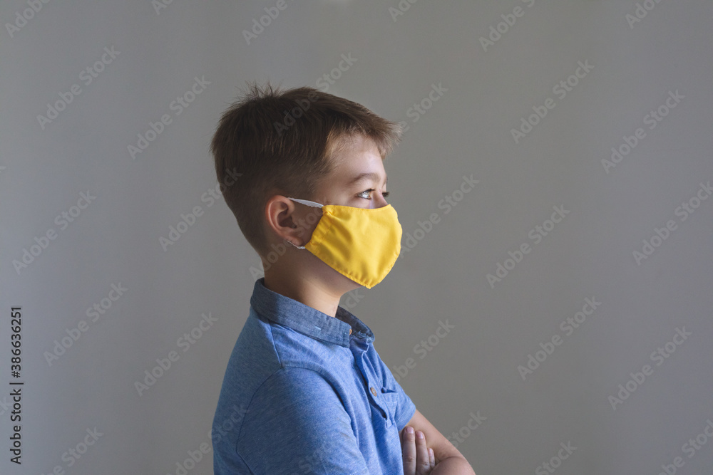 Side view of boy wearing face mask at home Side view of boy wearing face mask at home