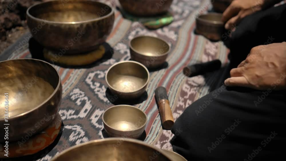 Asian guy playing Tibedt singing copper cups on a viewing mountain