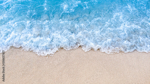 Wave of blue ocean on sandy beach background