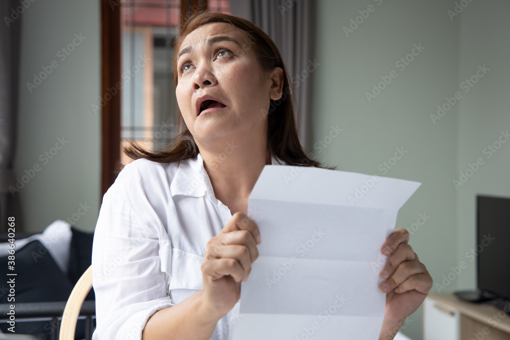 frustrated, shocked, stressed middle aged woman with expensive bill, debt invoice, eviction notice; concept of high cost of living, expensive bill, economic recession, no job no money frustrated, shocked, stressed middle aged woman with expensive bill, debt invoice, eviction notice; concept of high cost of living, expensive bill, economic recession, no job no money