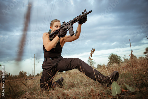 Sexy woman takes aim with rifle outdoors