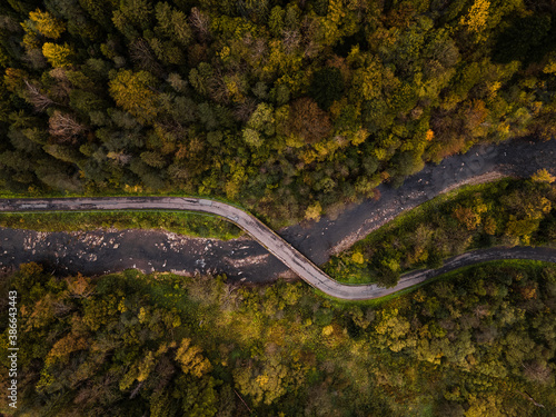 Winding Road and River in Autumn Forest. Aerial Drone Top Down View. Bieszczady in Poland