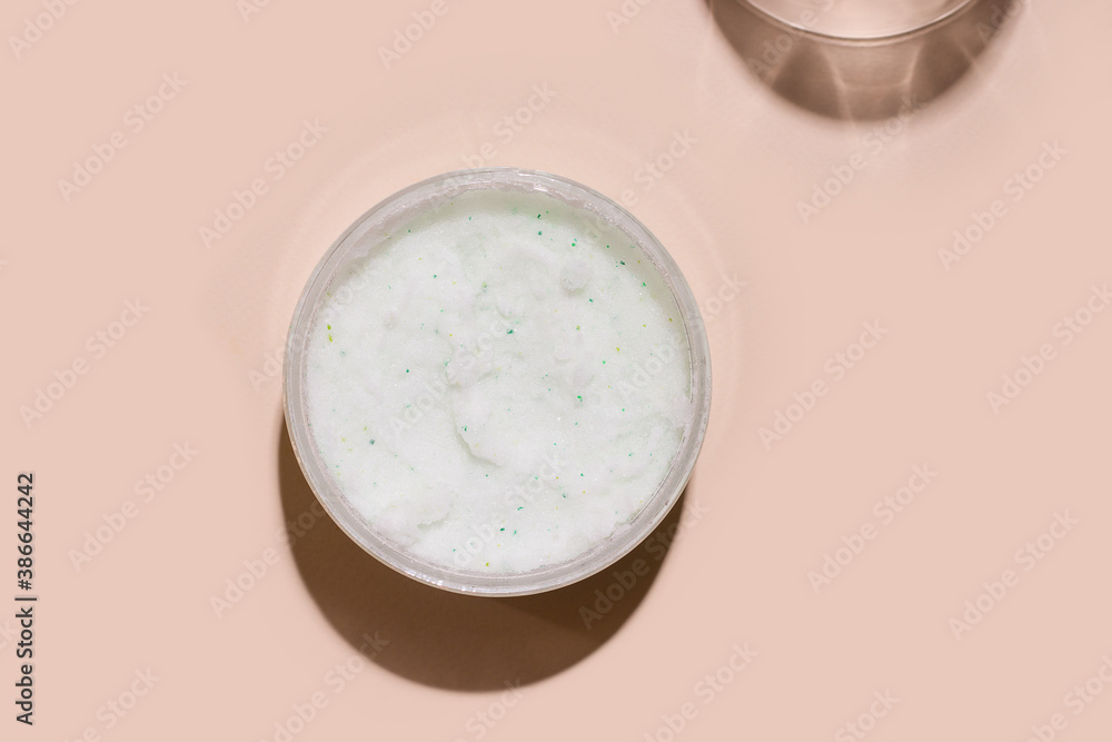 Body scrub cosmetics on beige background. View from above Body scrub cosmetics on beige background. View from above