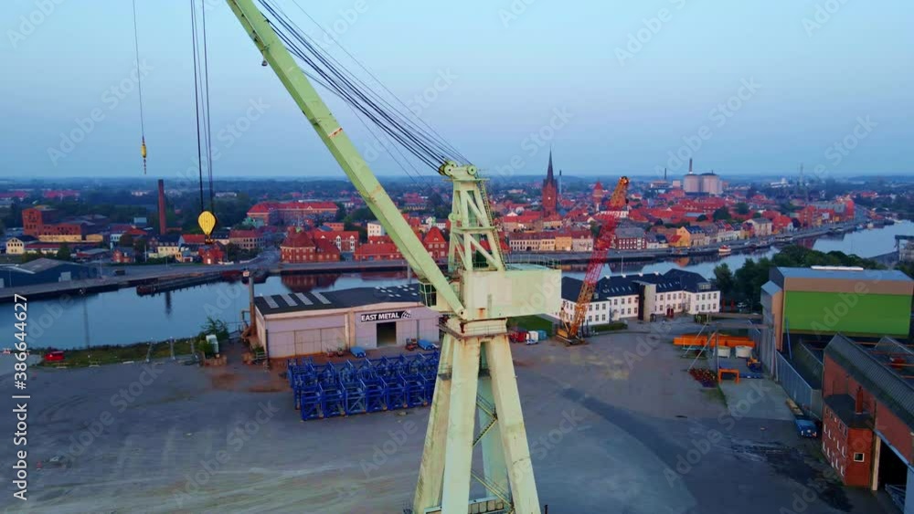 Giant industrial heavy lift crane in an old shipyard with warehouses in the background. Aerial photo. Giant industrial heavy lift crane in an old shipyard with warehouses in the background. Aerial photo.