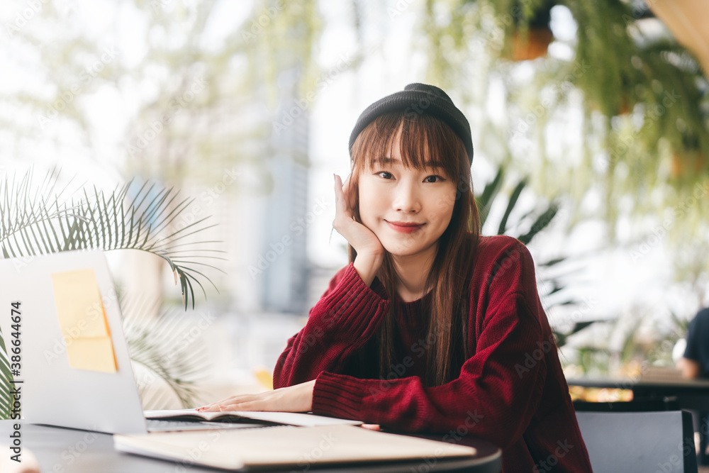 Portrait of young adult asian college student woman with laptop for study at cafe on winter day. Portrait of young adult asian college student woman with laptop for study at cafe on winter day.