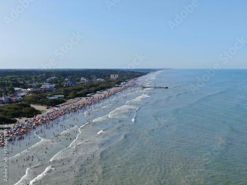 Vista desde un dron, de la costa del mar , un muelle, y personas en la playa, durante la temporada de vacaciones, en un día de sol.