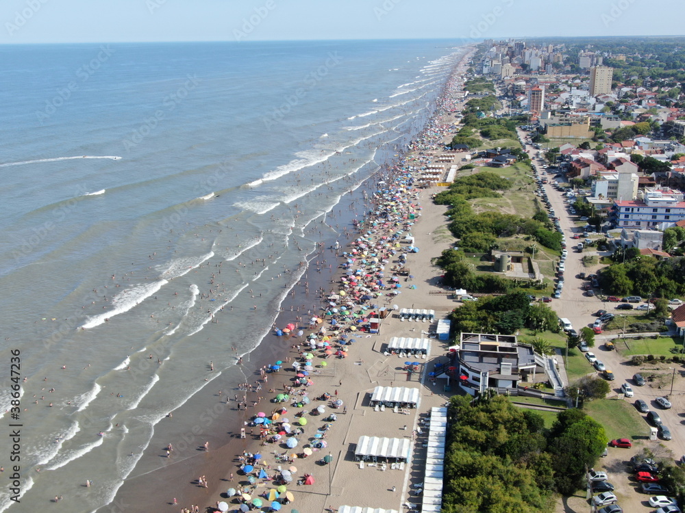 Vista desde un dron, de la costa del mar y los pueblos frente a la costa, durante la temporada de vacaciones en un día de sol.