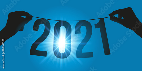 Carte de vœux avec deux mains qui tiennent une guirlande à contre jour pour présenter la nouvelle année 2021.