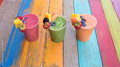 Colorful, tasty and healthy fruit smoothies on a colorful wood table