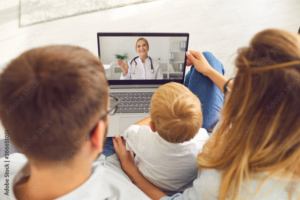 Young family with a son makes a video call via laptop to a pediatrician for advice and counseling.