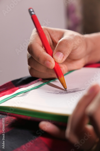 Close up of women hand writing on notepad.