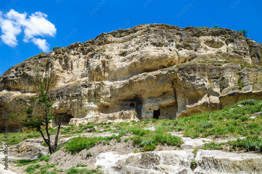 Rocks beneath cave city-fortress Chufut-Kale, Bakhchisaray, Crimea. City itself is on top of them. Artificial caves near ground was used as storages, stables or even as appartments of villagers