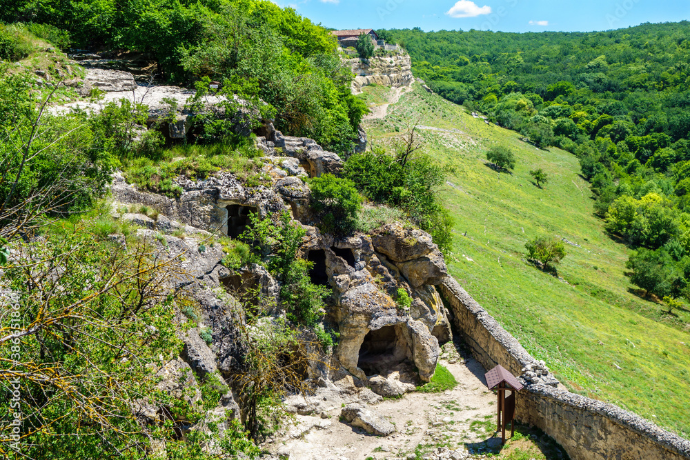Panorama of residential caves inside ancient city Chufut Kale, Bakhchisaray, Crimea. Also there are outer walls on egde of rocks