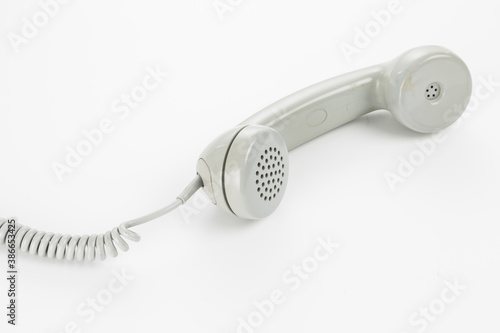 Detail photo of a gray vintage rotary telephone in a bright studio setting.