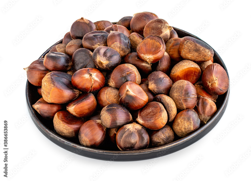 Roasted chestnuts on a round plate isolated on white background. Healthy nuts closeup. Roasted chestnuts on a round plate isolated on white background. Healthy nuts closeup.